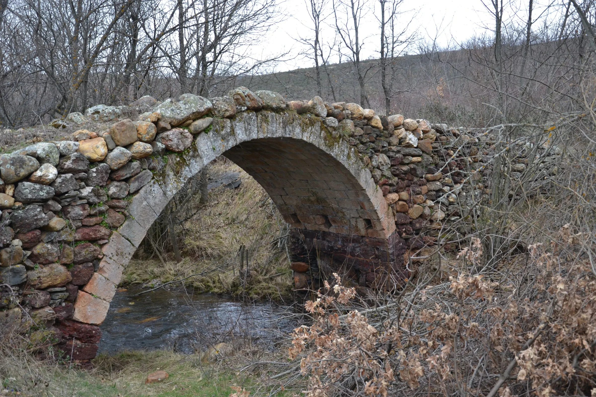 El puente de cantería de Villacorta sobre el Vadillo, de un solo arco, con el aro de sillería y los tímpanos de mampostería