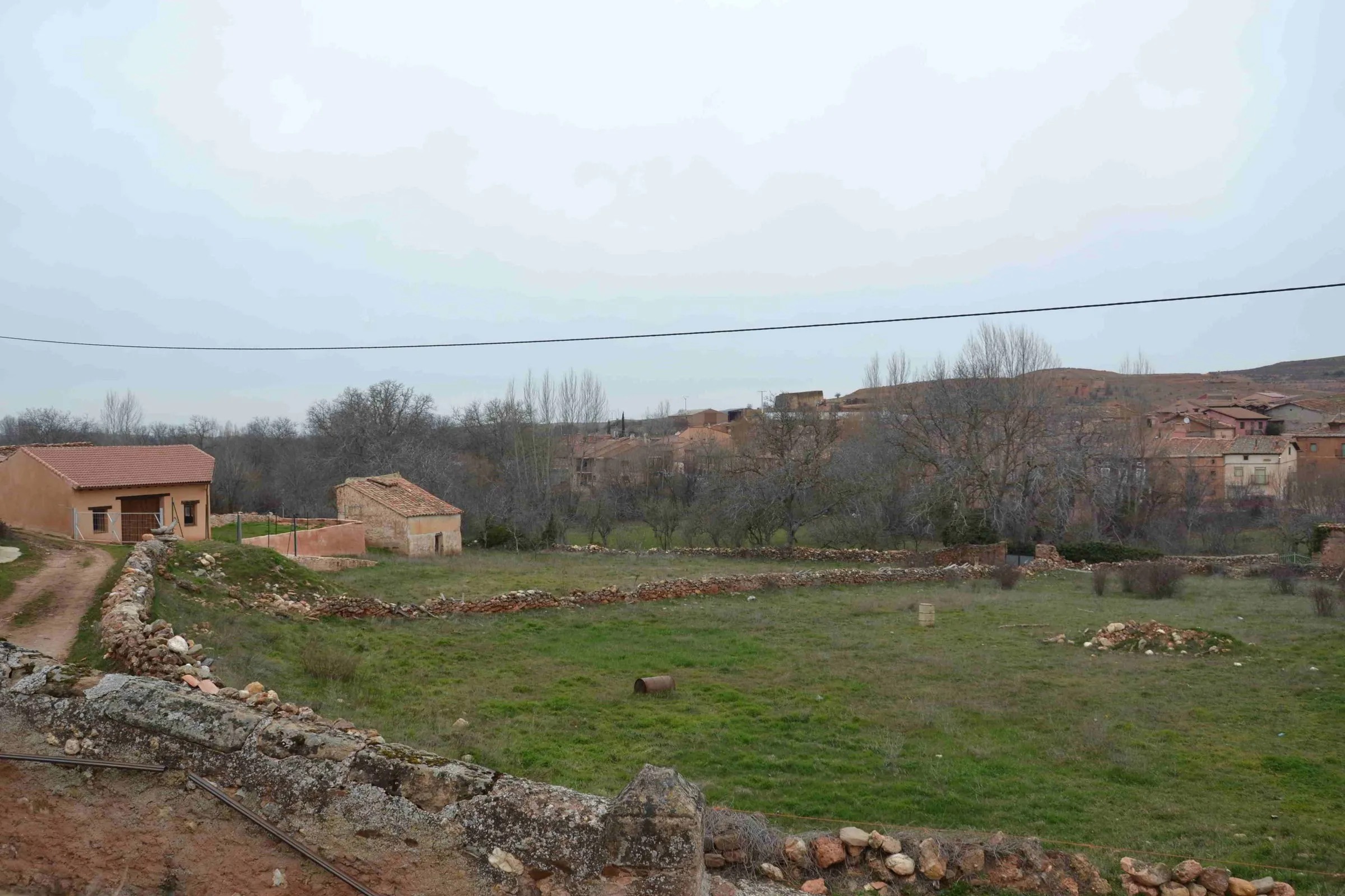 Estebanvela desde los prados, con su caserío de piedra rojiza
