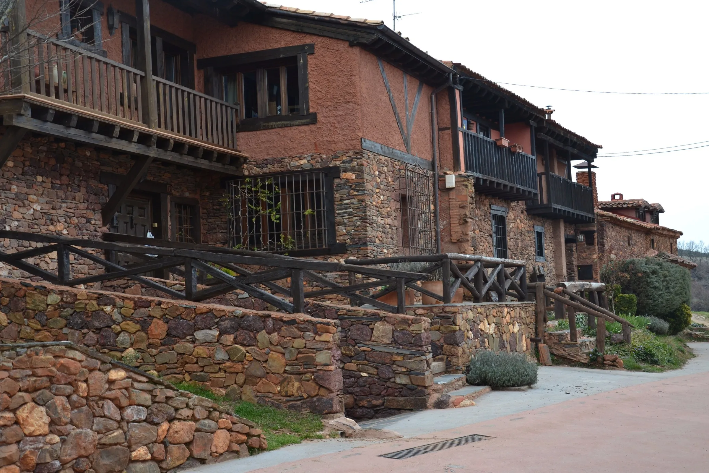 Casas de arenisca roja con balcones de madera en una calle de Madriguera