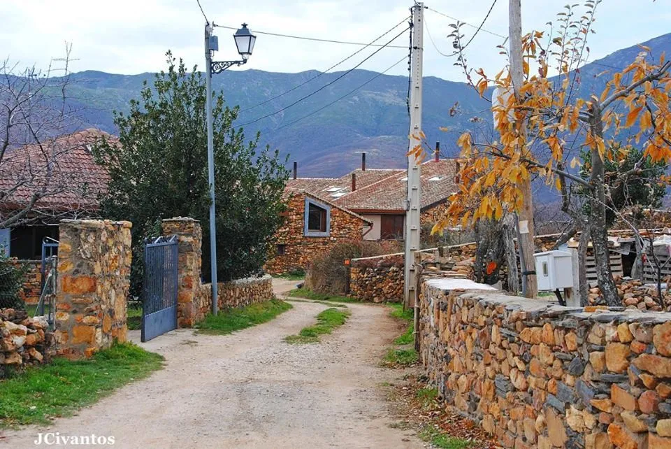 Calle de Martín Muñoz de Ayllón entre muros de cuarcita, con la sierra al fondo