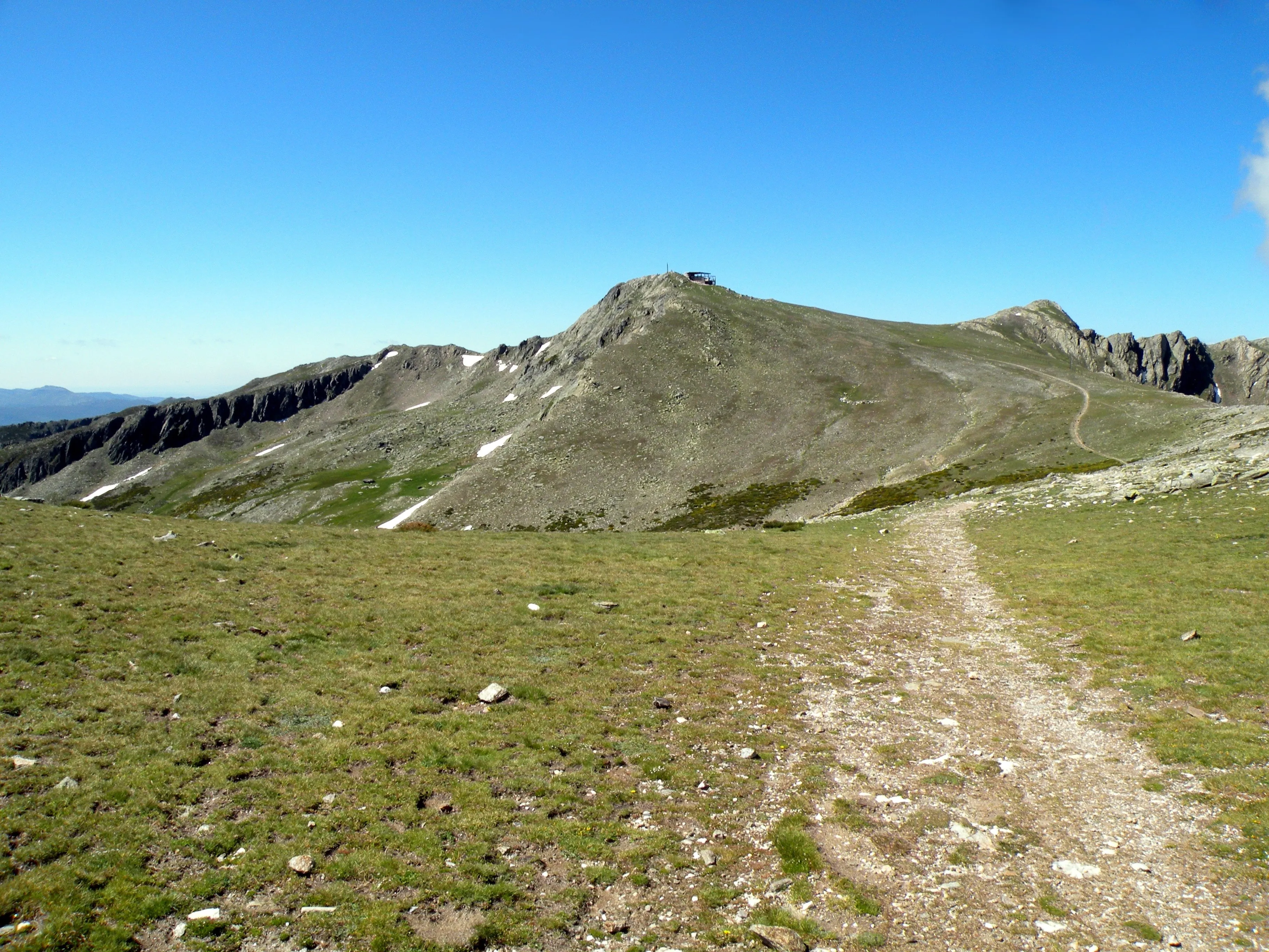 La cumbre del Pico del Lobo con el camino que sube por la loma, en verano