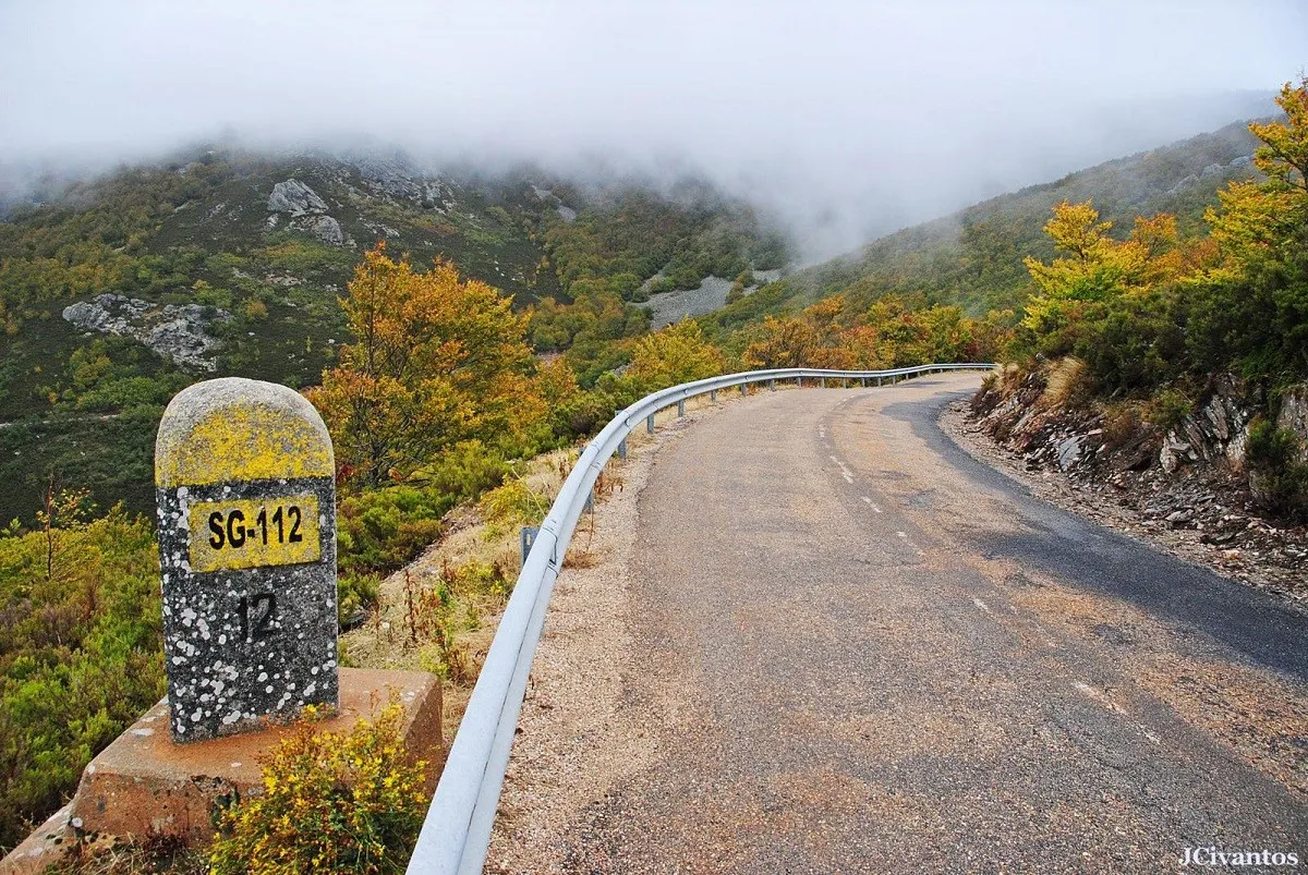La carretera SG-112 subiendo al puerto de la Quesera en otoño, entre niebla y hayedo